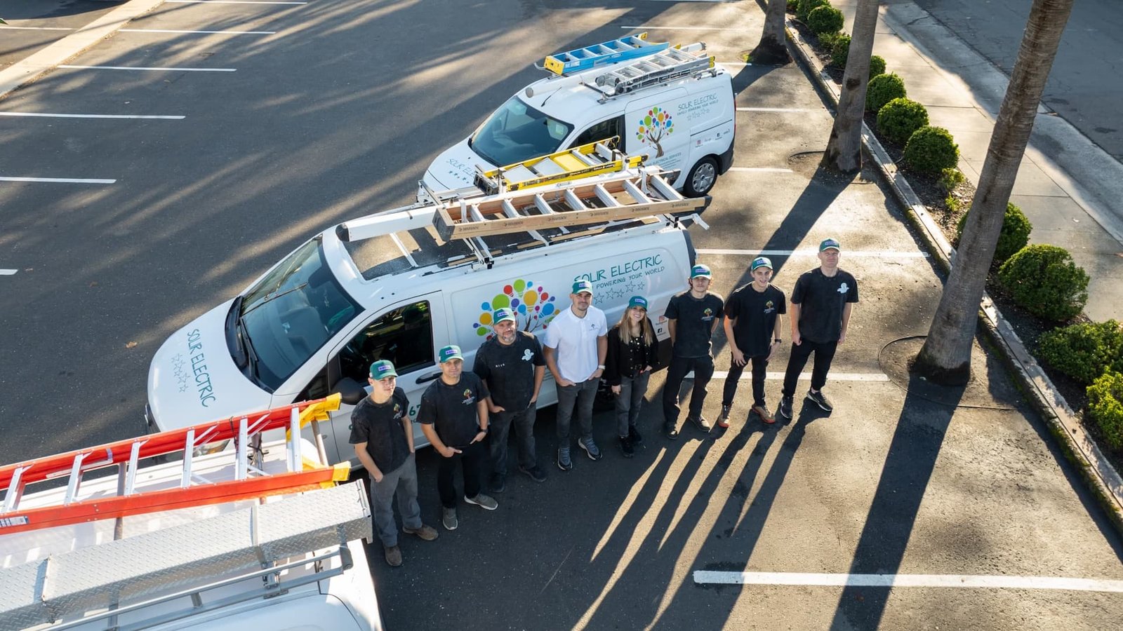 Solir Electric team beside branded service vans, photographed from above