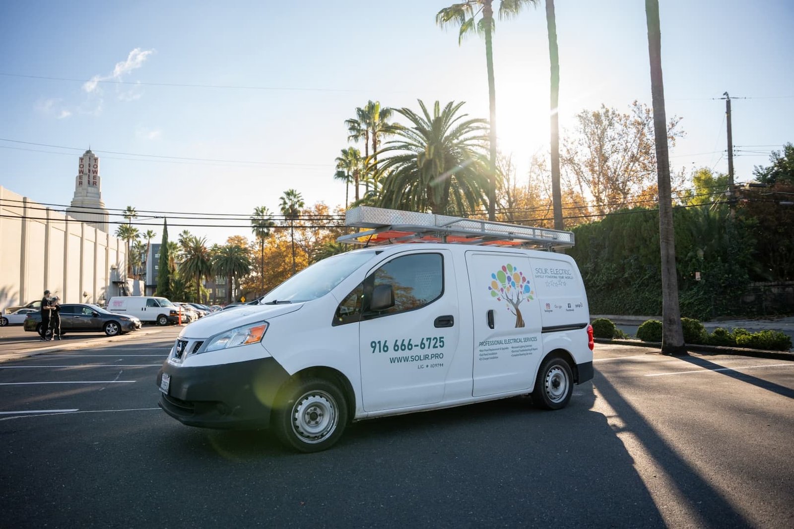 White Solir Electric service van with a roof ladder parked in afternoon sunlight