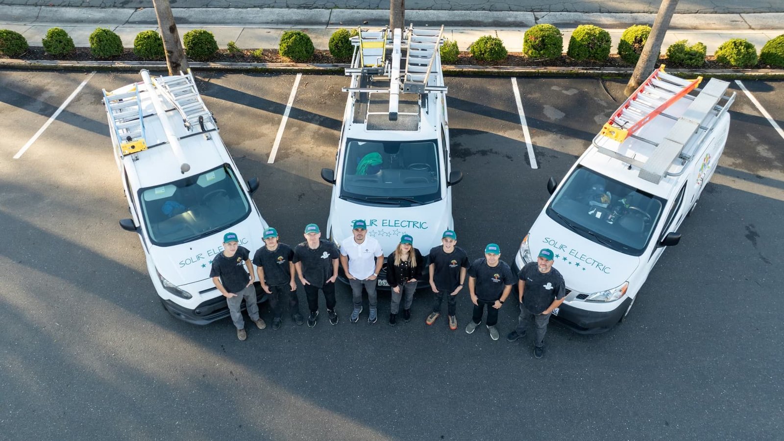 Overhead view of the Solir Electric team standing in front of three service vehicles